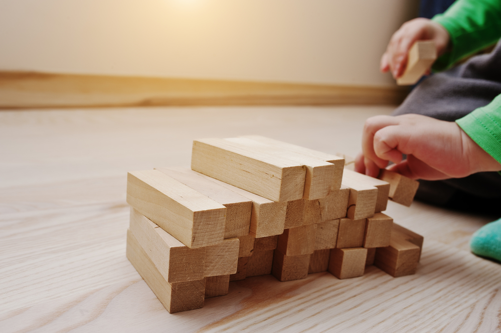 toddler stacking wooden blocks